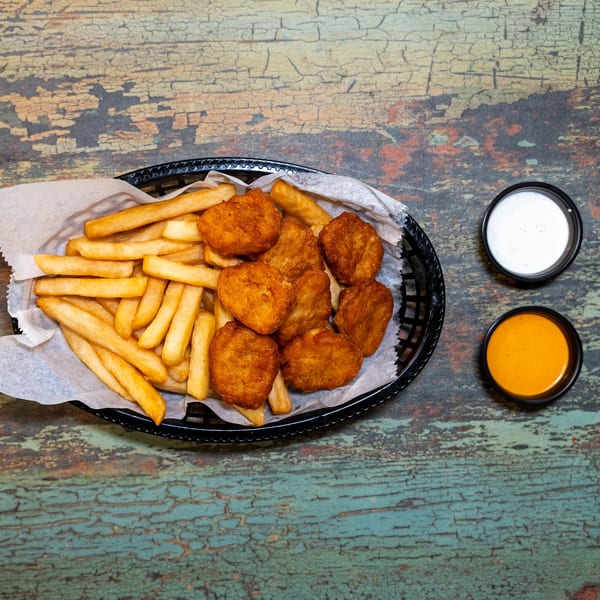 A basket of golden-brown halal chicken nuggets and french fries with two dipping sauces.